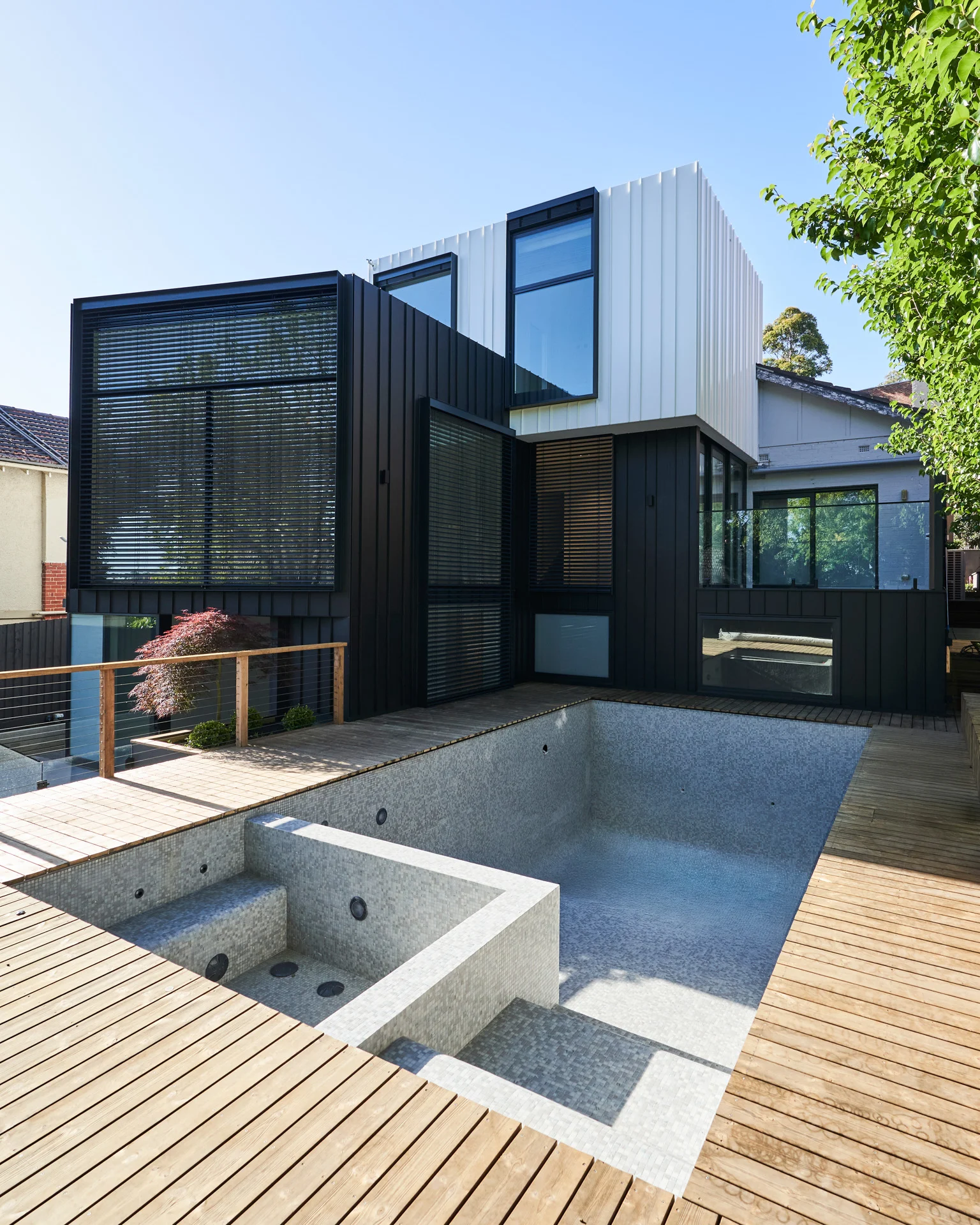 Glen Iris residence, full-height glazing framed by dark steel and white walls
